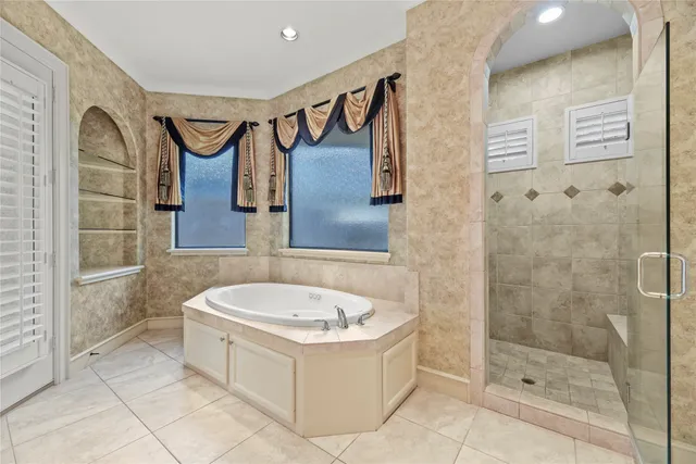 a bathroom with a tub a sink and glass door shower