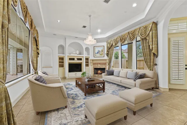 a living room with furniture fireplace and large windows
