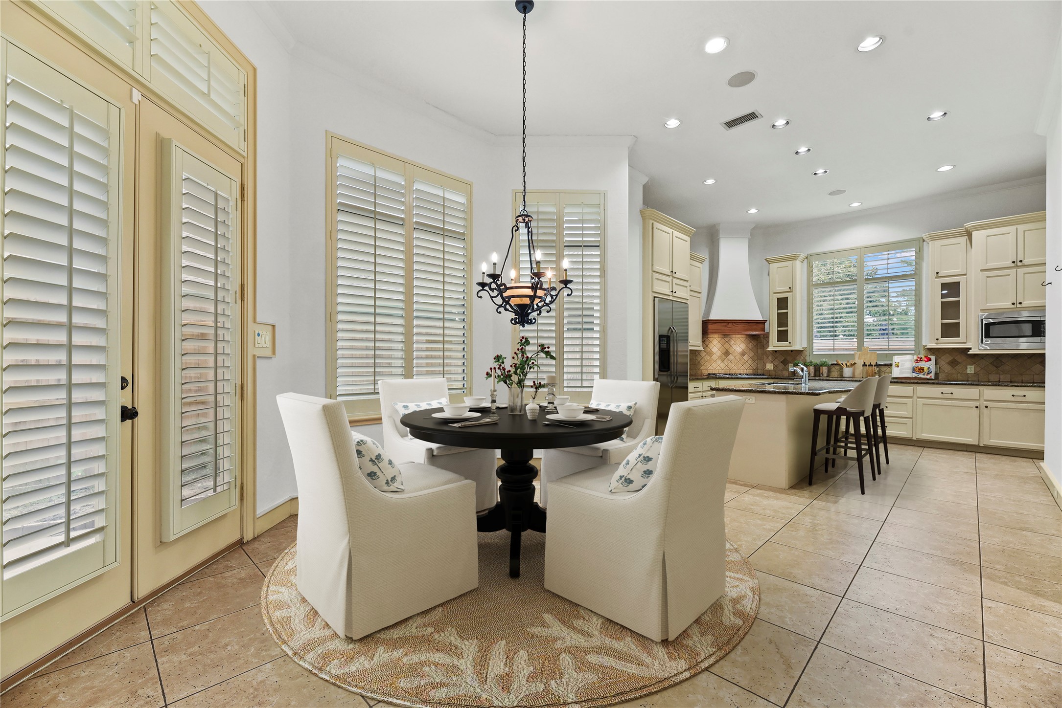 16610 Champagne Falls Court Spring, TX 77379 - Photo 8 of 45 a kitchen with stainless steel appliances kitchen island granite countertop a refrigerator a sink a stove a dining table and chairs