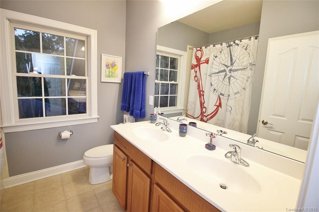 943 Cove Point Lane Tega Cay, SC 29708 - Photo 22 of 24 a bathroom with a double vanity sink mirror and toilet