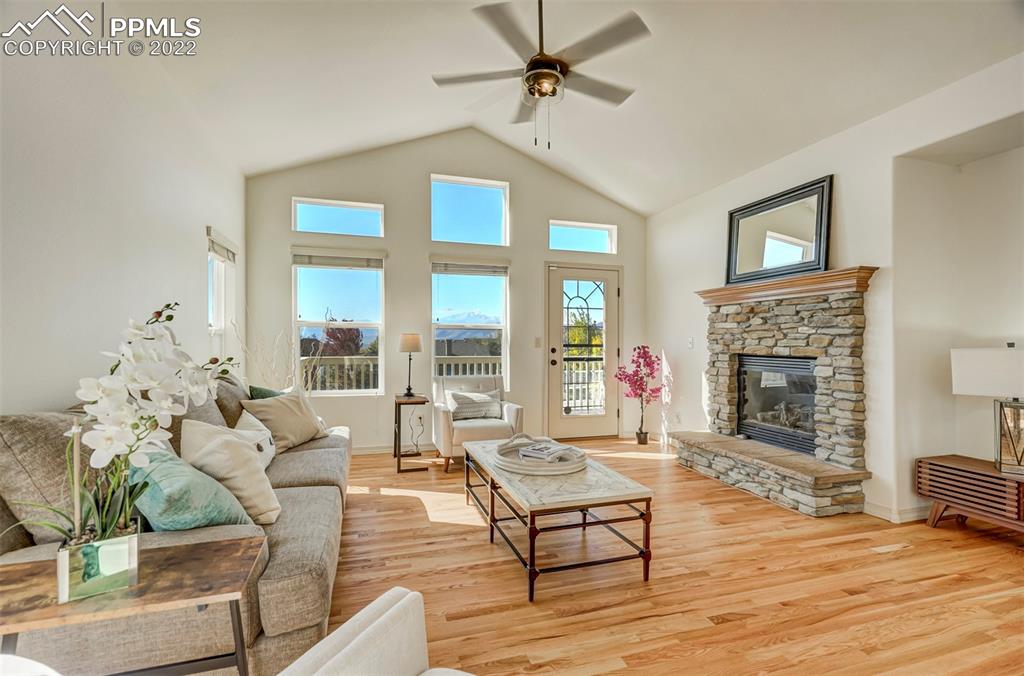 2323 Cinnabar Road Colorado Springs, CO 80921 - Photo 5 of 50 a living room with furniture a fireplace and a floor to ceiling window