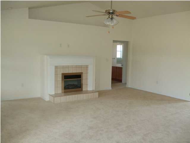34 Shipwreck Road Santa Rosa Beach, FL 32459 - Photo 3 of 6 an empty room with a fireplace and fan