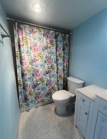 a bathroom with a toilet and a shower curtain
