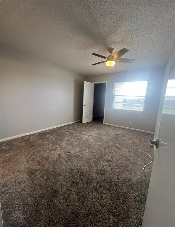 3050 Wolverton C, Unit 3050 Boca Raton, FL 33434 - Photo 15 of 19 an empty room with a chandelier fan and windows