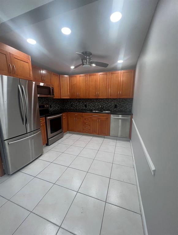 3050 Wolverton C, Unit 3050 Boca Raton, FL 33434 - Photo 2 of 19 a kitchen with granite countertop a refrigerator and a sink