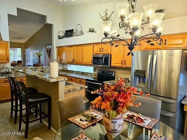 a kitchen with stainless steel appliances granite countertop a refrigerator and a stove top oven