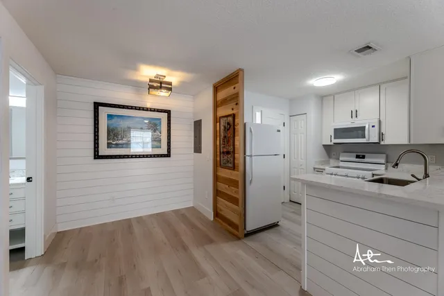 a kitchen with a refrigerator and a stove top oven