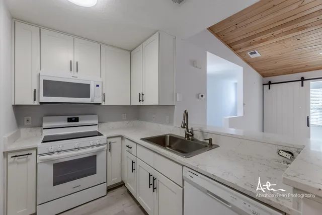 a kitchen with white cabinets and white appliances