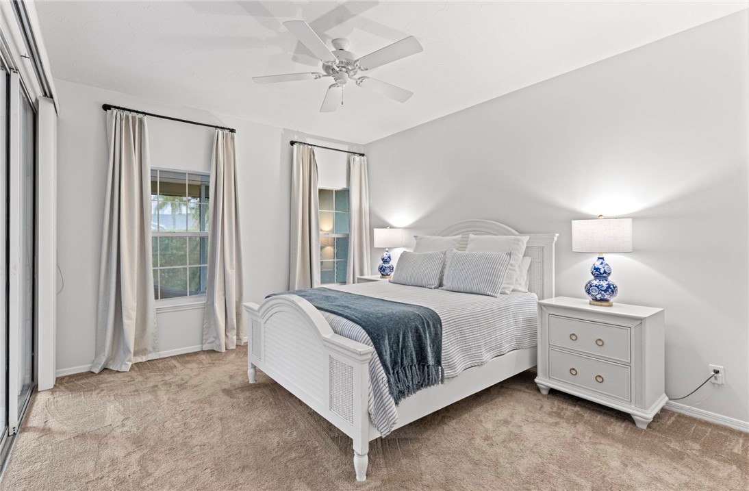 750 Timber Ridge Trail Southwest Vero Beach, FL 32962 - Photo 11 of 26 a spacious bedroom with a bed and a chandelier