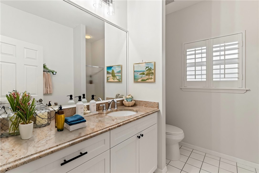 750 Timber Ridge Trail Southwest Vero Beach, FL 32962 - Photo 17 of 26 a bathroom with a granite countertop sink a toilet and a mirror