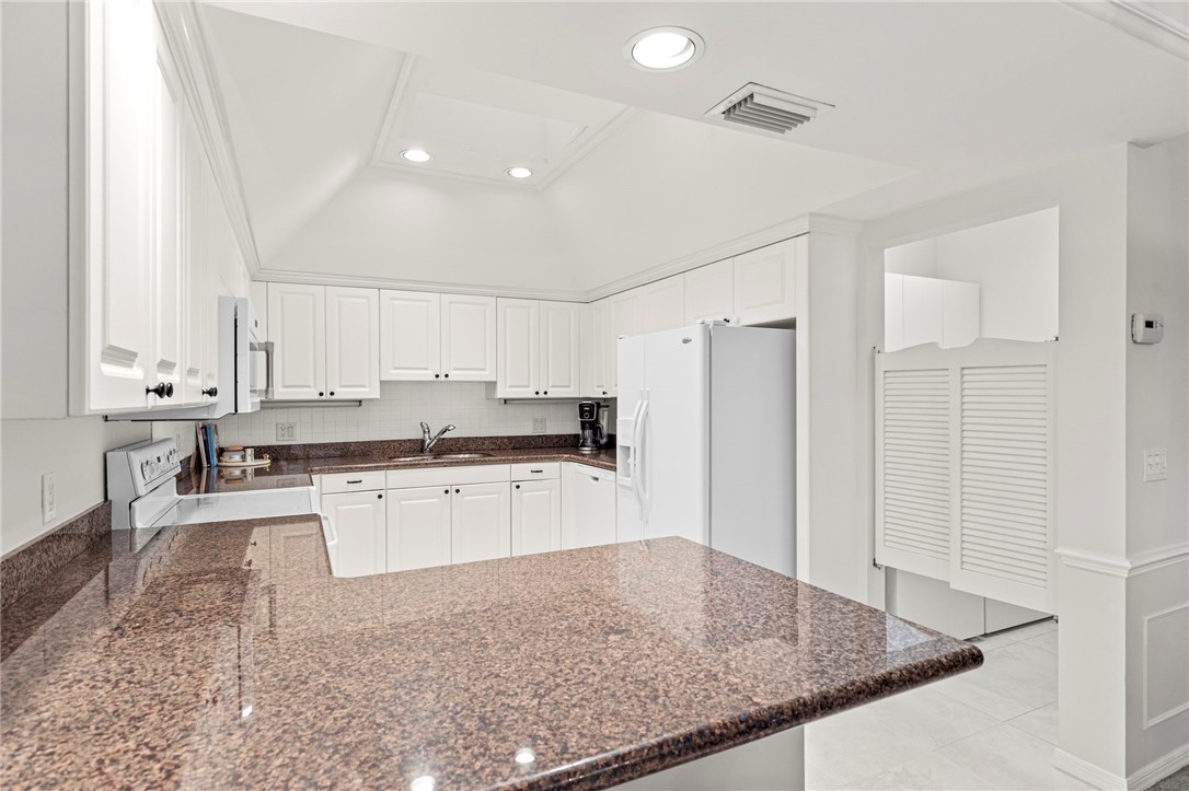 750 Timber Ridge Trail Southwest Vero Beach, FL 32962 - Photo 4 of 26 a kitchen with stainless steel appliances granite countertop a sink refrigerator and cabinets