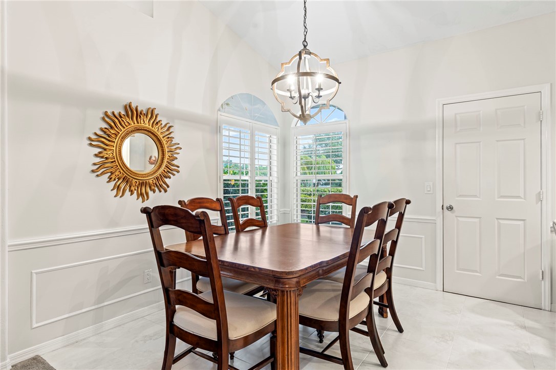 750 Timber Ridge Trail Southwest Vero Beach, FL 32962 - Photo 6 of 26 a view of a dining room with furniture a chandelier and wooden floor