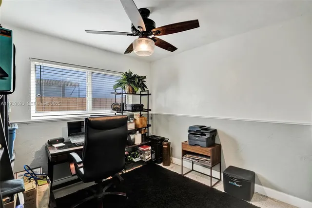 a view of a livingroom with workspace and a window