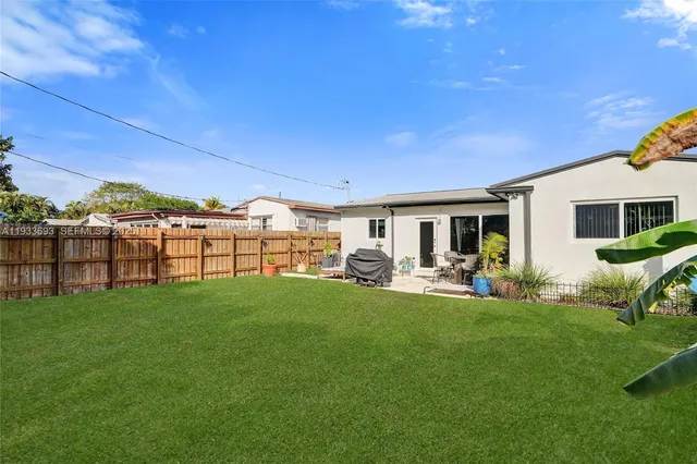 an aerial view of residential houses with outdoor space and trees