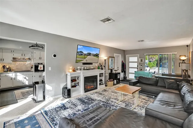 a kitchen with a refrigerator a sink and dishwasher with white cabinets