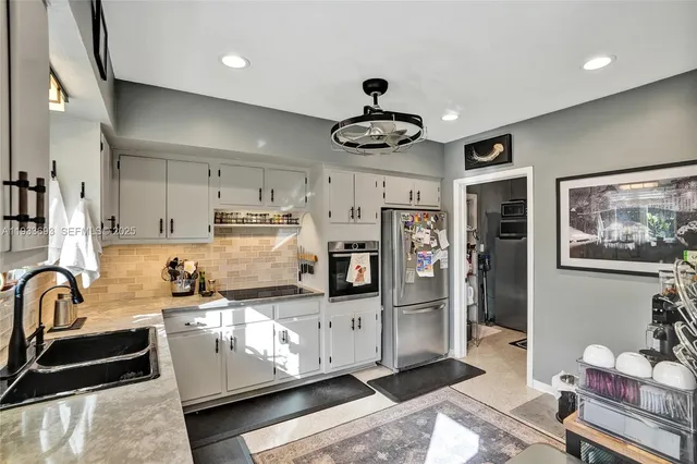 a kitchen with stainless steel appliances granite countertop a sink stove and cabinets
