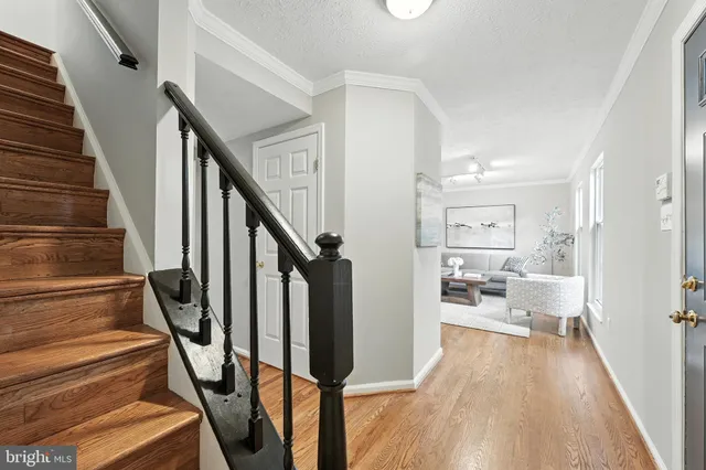 a view of a hallway with wooden floor and staircase