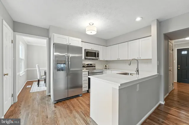 a kitchen with a sink a refrigerator and a stove top oven