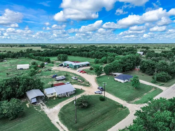 a view of a house with a big yard and a large trees