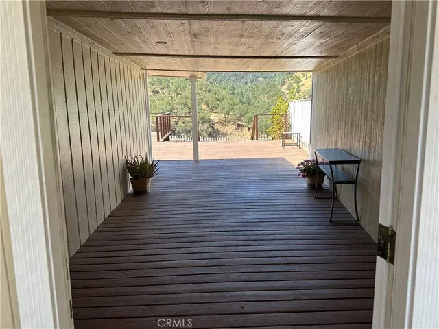 a view of a hallway with wooden floor and windows