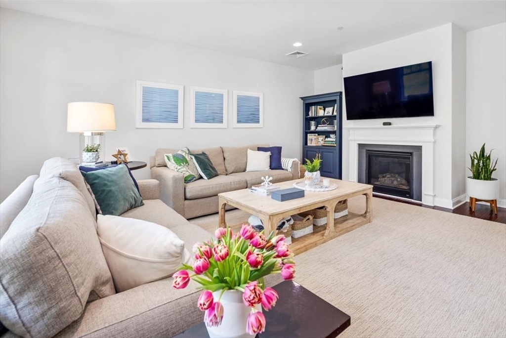 159 Hms Stayner Drive, Unit 159 Hingham, MA 02043 - Photo 3 of 35 a living room with furniture a flat screen tv and a fireplace