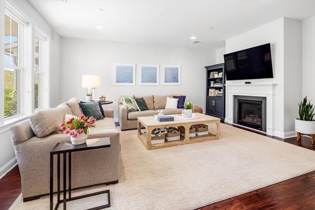 159 Hms Stayner Drive, Unit 159 Hingham, MA 02043 - Photo 4 of 35 a living room with furniture a flat screen tv and a fireplace