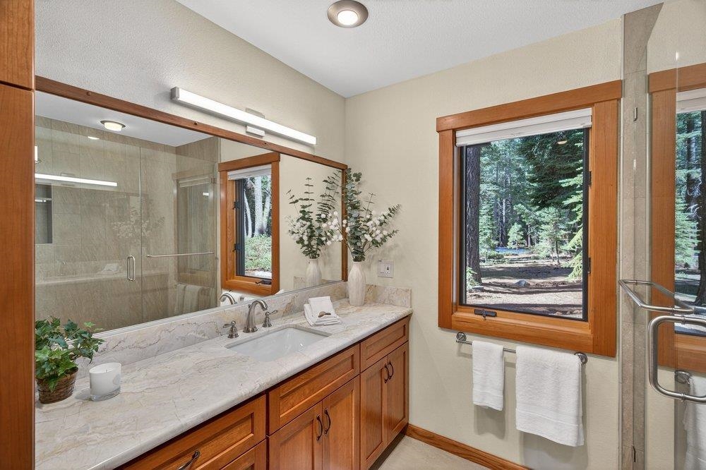 12964 Falcon Point Place Truckee, CA 96161 - Photo 19 of 28 a bathroom with a granite countertop sink mirror and a shower