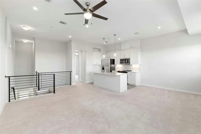 a view of a kitchen with refrigerator and a sink
