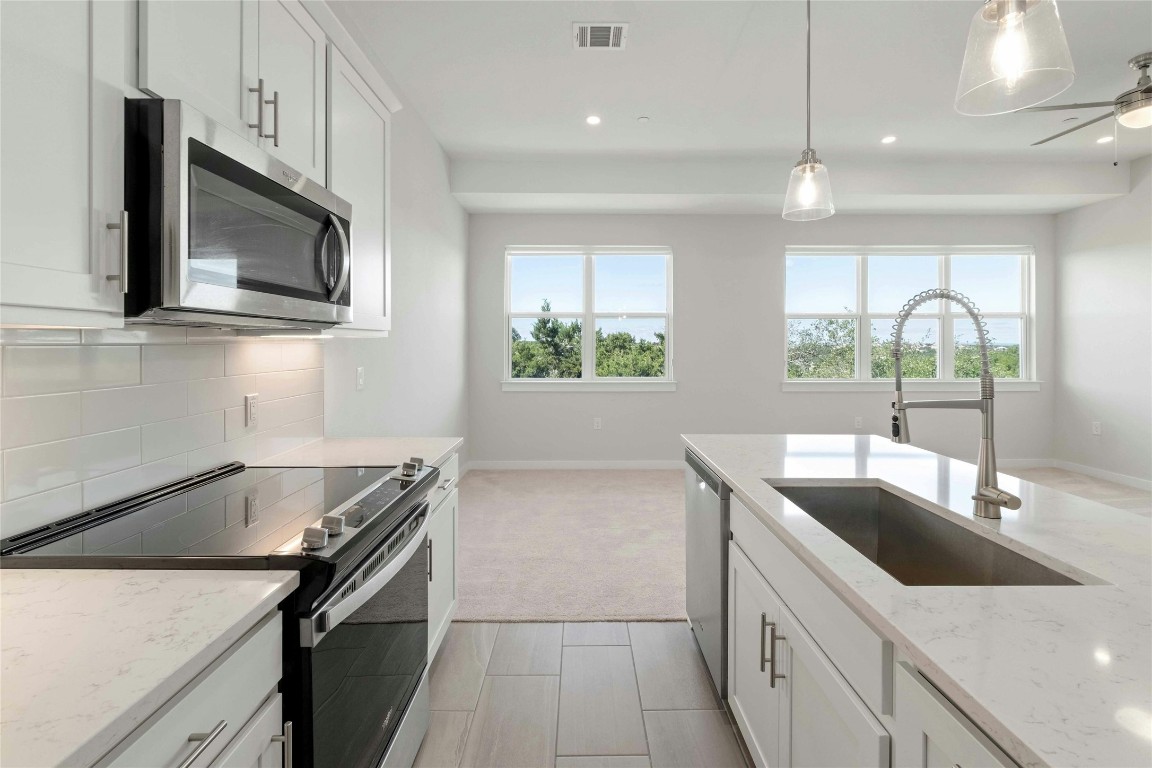 12001 Vista Parke Drive, Unit 702 Austin, TX 78726 - Photo 13 of 33 a kitchen with a sink and a microwave