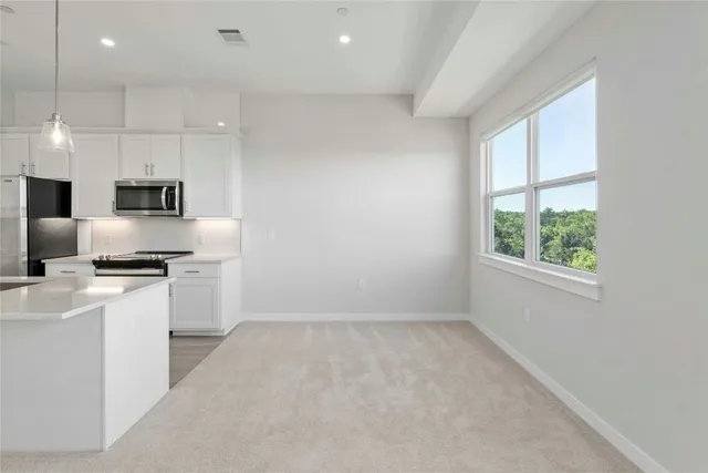 a kitchen with kitchen island a sink stainless steel appliances and window
