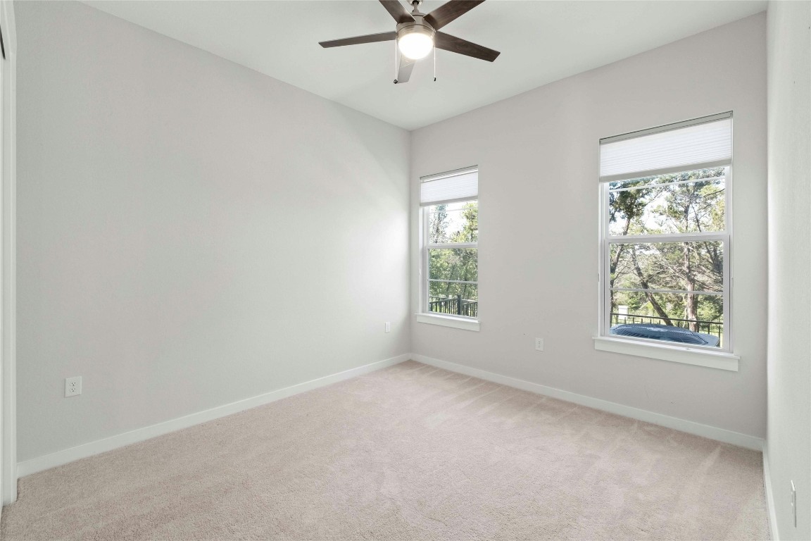 12001 Vista Parke Drive, Unit 702 Austin, TX 78726 - Photo 23 of 33 an empty room with a window and a ceiling fan