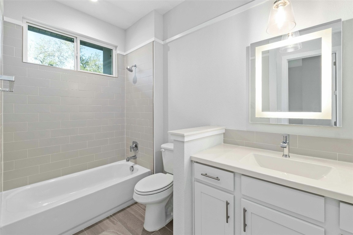 12001 Vista Parke Drive, Unit 702 Austin, TX 78726 - Photo 24 of 33 a bathroom with a sink a toilet and shower