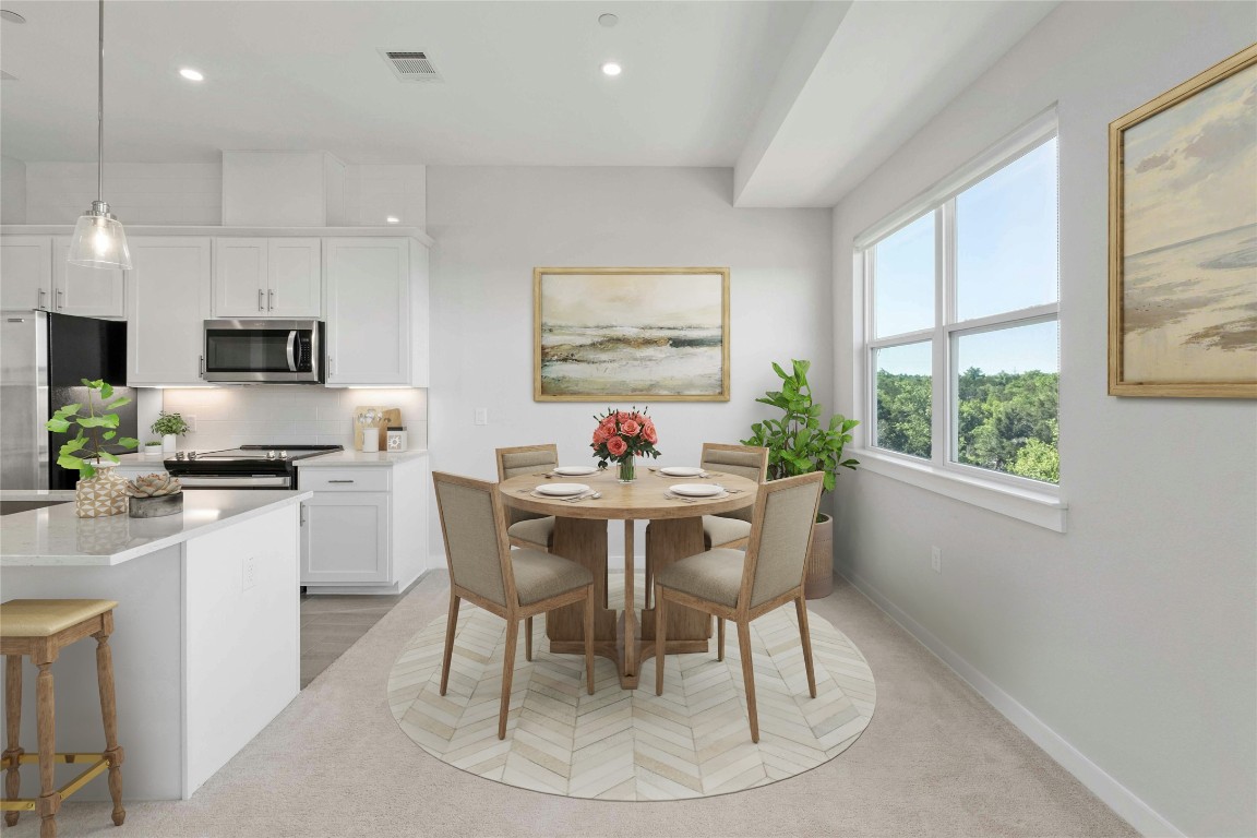 12001 Vista Parke Drive, Unit 702 Austin, TX 78726 - Photo 5 of 33 a dining room with kitchen island granite countertop a table chairs a sink dishwasher a dining table and chairs with wooden floor
