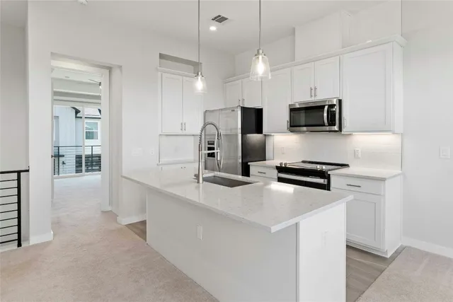 a kitchen with stainless steel appliances a microwave a sink and refrigerator