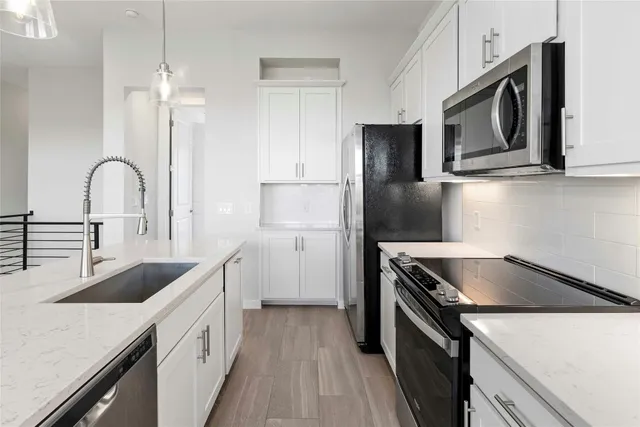 a kitchen with granite countertop a sink stainless steel appliances and cabinets