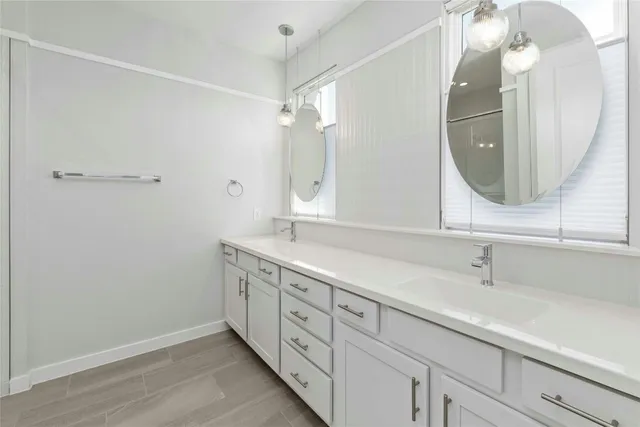 a bathroom with a double vanity sink and a mirror