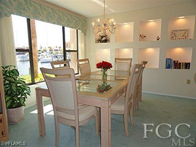 3235 Sugarloaf Key Road, Unit 12A Punta Gorda, FL 33955 - Photo 4 of 8 a dining room with furniture potted plants and wooden floor