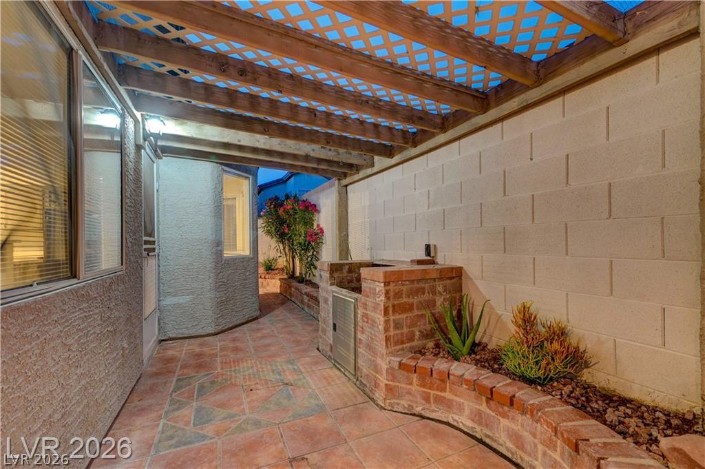 2283 Ramsgate Drive Henderson, NV 89074 - Photo 42 of 51 Tiled flooring and a robust wooden pergola define this sheltered outdoor patio space.
