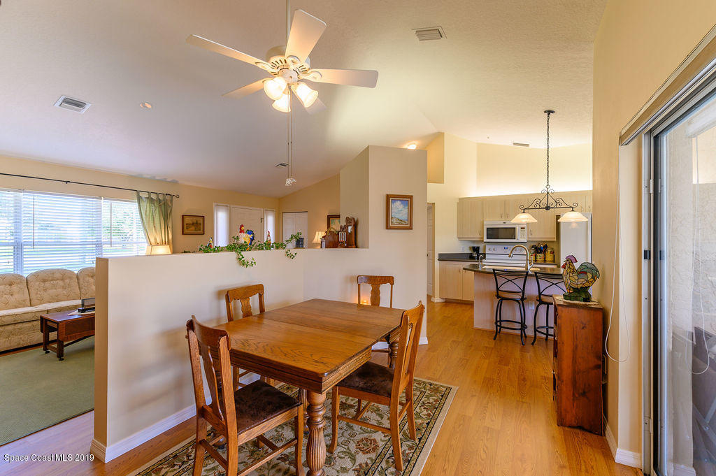 3525 Shady Run Road Melbourne, FL 32934 - Photo 23 of 32 a view of a dining room with furniture and a chandelier