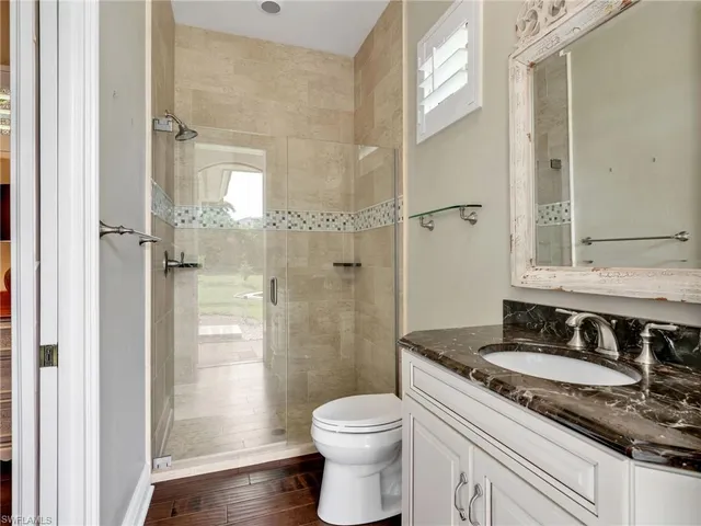 a bathroom with a granite countertop sink toilet and shower