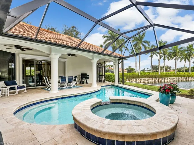 a view of a swimming pool with a dining table and chairs