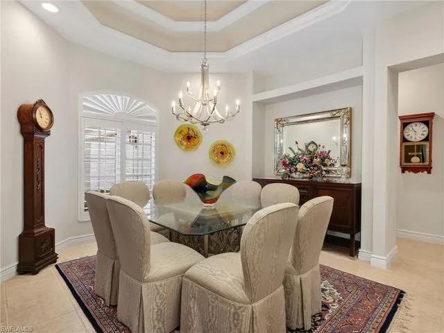 a dining room with furniture a chandelier and wooden floor