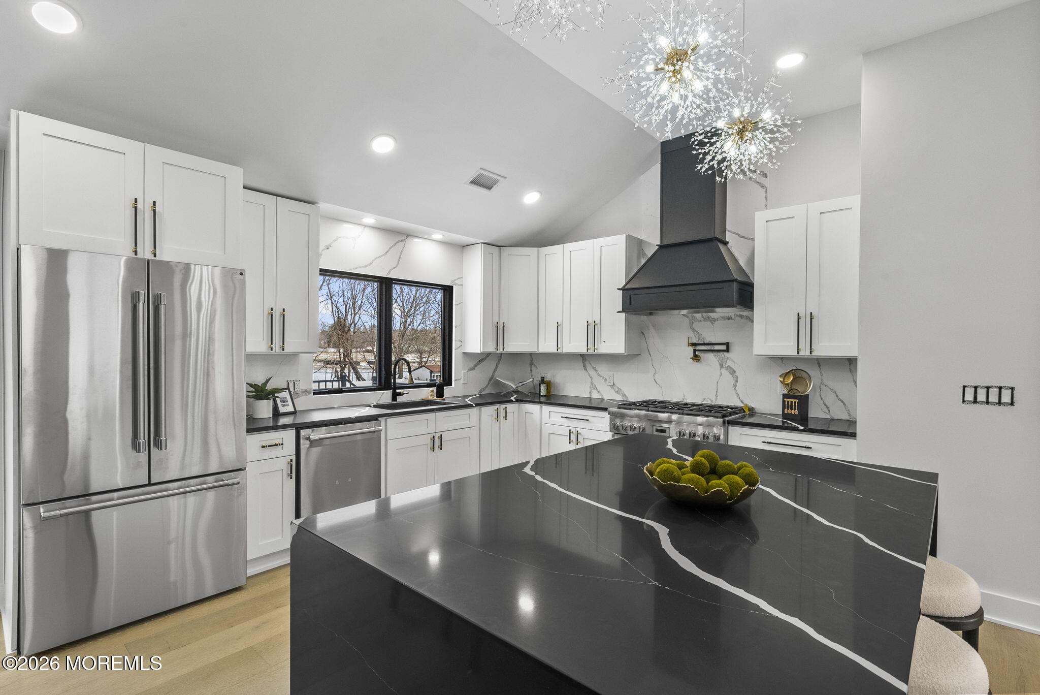 a kitchen with stainless steel appliances granite countertop a sink a stove and a refrigerator