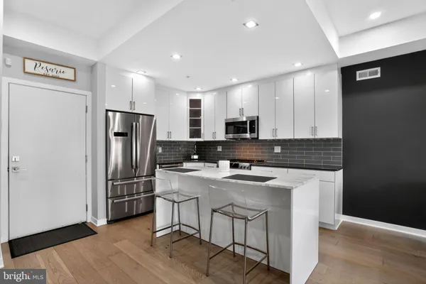 a kitchen with stainless steel appliances a refrigerator a sink a stove a microwave a counter top and oven