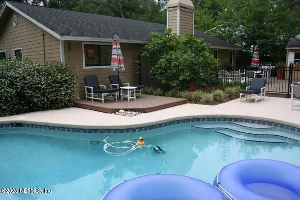 a view of a house with swimming pool and sitting area