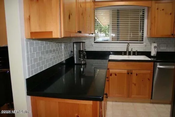 a kitchen with granite countertop sink and cabinets