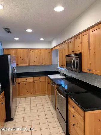 a kitchen with stainless steel appliances granite countertop a stove a sink and a microwave
