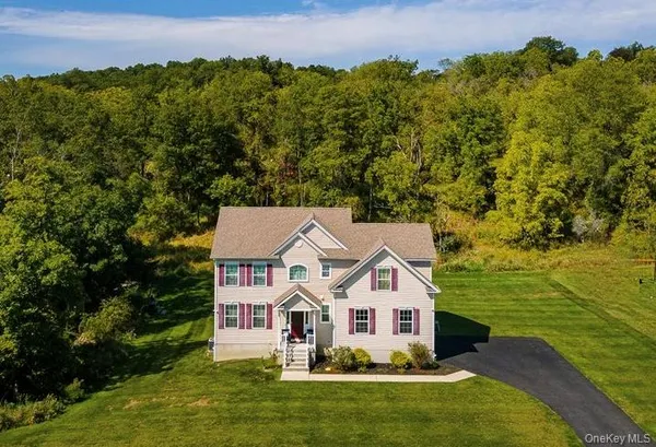 an aerial view of a house with a garden and lake view
