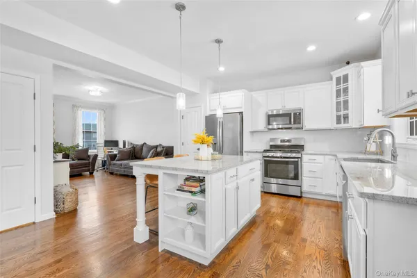 a kitchen with stainless steel appliances granite countertop a stove refrigerator and a sink