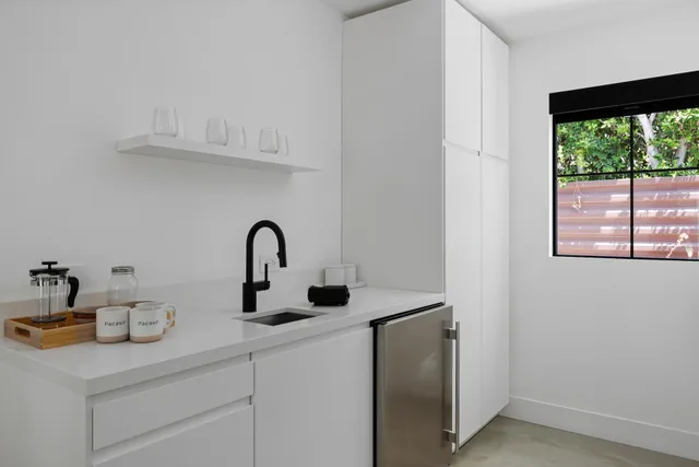 a bedroom with a bed and a refrigerator